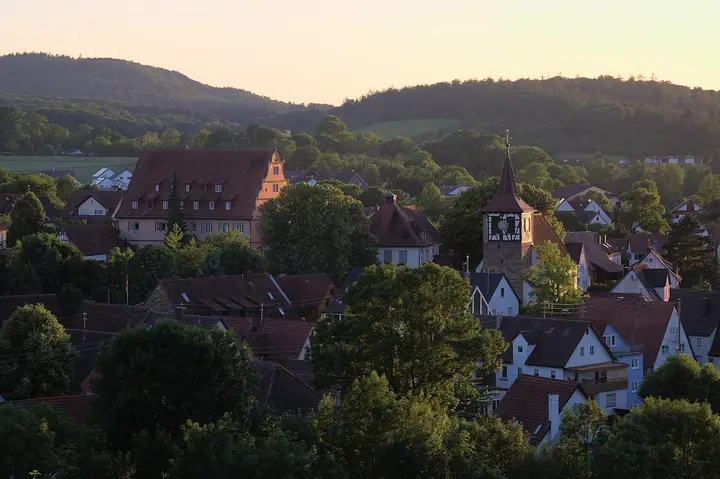 Blick vom Spitzenberg auf Zaberfeld mit evangelischer Kirche und Schloß kurz vor Sonnenuntergang im Juni 2022.